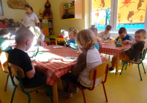 Dzieci oglądają przy użyciu lup różne nasiona i cebulki roślin.